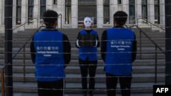 FILE - Activists set up a mock Uyghur forced labor camp during a protest in Washington, D.C., March 4, 2022.
