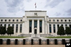 Bendera Amerika berkibar di atas gedung Federal Reserve di Washington, DC, 4 Mei 2021. (AP/Patrick Semansky, File)