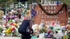 FILE - Reggie Daniels pays his respects at a memorial at Robb Elementary School in Uvalde, Texas, on June 9, 2022, honoring the two teachers and 19 students killed in the shooting at the school on May 24. 