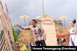 Bupati Temanggung, HM Al Khadziq, memercikkan air ke rigen dalam doa bersama ribuan petani tembakau, Minggu (7/8) di kawasan Kledung. Rigen adalah tempat menjemur tembakau. (Foto: Humas Temanggung)