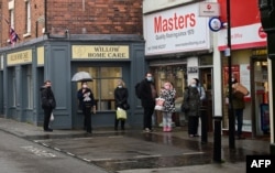 Warga antre di luar kantor pos di Whitchurch, Inggris tengah, 13 Desember 2021, (Paul ELLIS / AFP)