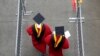 Para mahasiswa berjalan memasuki stadion High Point Solutions sebelum acara wisuda Universitas Rutgers dimulai di Piscataway Township, New Jersey, pada 13 Mei 2018. (Foto: AP/Seth Wenig)