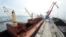 FILE - A cargo ship is loaded with coal during the opening ceremony of a new dock at the North Korean port of Rajin. The dock was jointly built with Russia after last year's completion of a railway link to North Korea.