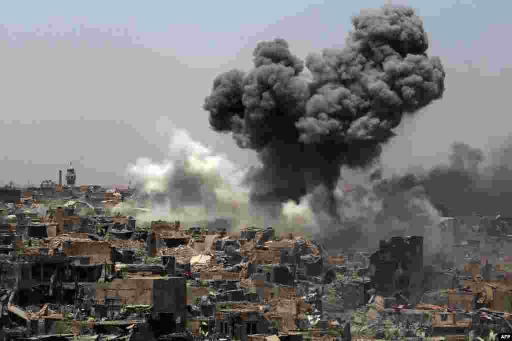 Smoke billows following an airstrike by U.S.-led international coalition forces targeting Islamic State (IS) group in Mosul, Iraq.