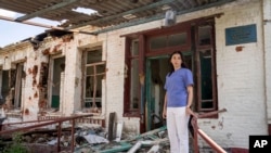 一名医生站在乌克兰哈尔科夫地区被俄罗斯攻击摧毁的一所医院前（2022年7月31日）