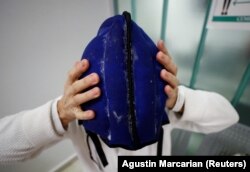 Pasien kanker Elsa Ram sedang memasang helm darurat dari kantong es yang mencegah kerontokan rambut, selama sesi kemoterapi, di Buenos Aires, Argentina 4 Agustus 2022. (Foto: REUTERS/Agustin Marcarian)