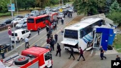 Police escort migrants to board a bus at the scene of an incident, in the Black Sea city of Burgas, Bulgaria, Aug. 25, 2022. (Bulgarian News Agency via AP)