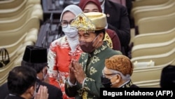 Presiden Joko Widodo (tengah) menyapa anggota parlemen sebelum menyampaikan pidato tahunannya di parlemen di Jakarta pada 16 Agustus 2022, menjelang perayaan Hari Kemerdekaan. (Foto: AFP/BAGUS INDAHONO)