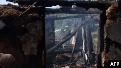 A Ukrainian firefighter puts out the fire in a destroyed house following a Russian shelling in the town of Bakhmut, Donetsk region, Aug. 24, 2022, amid Russia's invasion of Ukraine.