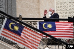 In this file photo taken on August 15, 2022, Malaysia's former prime minister Najib Razak waves as he arrives at the federal court in Putrajaya.