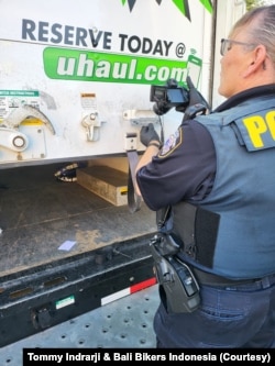 Seorang polisi memeriksa truk U-Haul yang pintu belakangnya terbuka sebagian. (Foto: Tommy Indrarji & Bali Bikers Indonesia)