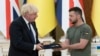 Presiden Ukraina Colodymyr Zelenskyy (kanan) memberikan penghargaan kepada Perdana Menteri Inggris pada saat itu, Boris Johnson, dalam kunjungan Johnson ke Kyiv, Ukraina, pada 24 Agustus 2022. (Foto: AP/Andrew Kravchenko)