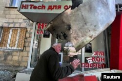 FILE - A man reacts at a residential area after a shelling with cluster ammunition, as Russia's attack on Ukraine continues, in Kharkiv, Ukraine, May 23, 2022.