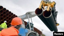 FILE - Steel pipes for the North Stream 2 pipeline are uploaded in Mukran harbour in Sassnitz, Germany.