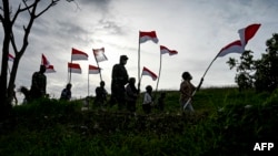 Para pemuda membawa bendera merah-putih saat memperingati HUT Kemerdekaan RI ke-76 di Banda Aceh, 16 Agustus 2021. 