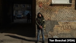 A civilian militia member takes guard in front of a base in downtown Kyiv, Ukraine, Feb. 25, 2022.