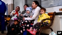 Refugees fleeing conflict from neighboring Ukraine wait at the railway station after arriving to Zahony, Hungary, Feb. 27, 2022.