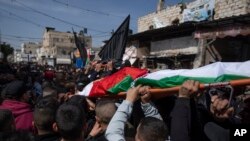 Para pelayat membawa Jenazah Shadi Najem (18, depan) dan anggota Jihad Islam, Abdullah al-Hossari (22), ke tempat pemakaman di kamp pengungsi Tepi Barat Jenin, Selasa, 1 Maret 2022. (AP/Nasser Nasser)