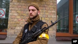 An armed civil defense man holds a Kalashnikov assault rifle while patrolling an empty street due to curfew in Kyiv, Ukraine, Feb. 27, 2022.