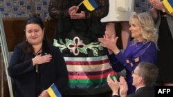 Ukraine Ambassador to the US Oksana Markarova acknowledges applause from US First Lady Jill Biden as they attend President Joe Biden's first State of the Union address to a joint session of Congress, in Washington, DC, on March 1, 2022.
