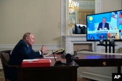 FILE - Russian President Vladimir Putin speaks via video conference at a summit of the Eurasian Economic Union in St. Petersburg, Russia, Oct. 14, 2021. Kazakhstan's President Kassym-Jomart Tokayev is seen on the screen.
