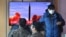 FILE - People watch a television screen showing a news broadcast with file footage of a North Korean missile test, at a railway station in Seoul, South Korea, on Feb. 27, 2022, 