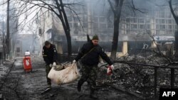 Police officers remove the body of a person killed in a March 1, 2022, airstrike that hit Kyiv's main television tower, March 2, 2022.