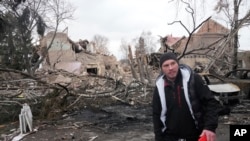 Seorang warga berjalan melewati sisa-sisa rumah budaya menyusul serangan udara malam hari di Desa Byshiv, 40 kilometer sebelah barat Kyiv, Ukraina, Jumat, 4 Maret 2022. (Foto: AP)