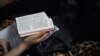 FILE - A woman holding a bible during a Christmas Eve service held by members of an underground church, at an apartment in Beijing, China, Dec. 24, 2014.