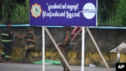 FILE - Soldiers and a firefighter provide security during a drug destruction event on the outskirts of Yangon, Myanmar, June 26, 2021. According to the U.N., armed groups on "both sides” of Myanmar’s conflict have been involved in the drug trade since last year’s coup.