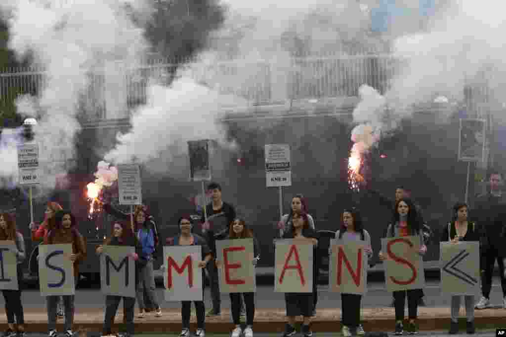 សមាជិក​នៃ​អង្គការ​យុវជន​បក្សកុម្មុយនិស្ត​ក្រិក (KKE) កាន់​កាំជ្រួច​ភ្លើង​គ្រវី​ ខណៈ​ពួកគេ​ឈរ​នៅ​ខាងក្រៅ​ស្ថានទូត​អាមេរិក​ក្នុង​ទីក្រុង Athens នៅ​ថ្ងៃច័ន្ទ ទី១ ខែមិថុនា ឆ្នាំ ២០២០ ដើម្បី​តវ៉ា​អំពី​មរណភាព​របស់​លោក George Floyd ដែល​ជា​ពលរដ្ឋ​អាមេរិក​ដើមកំណើត​អាហ្រ្វិក។ (AP)