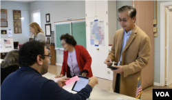 លោកយ័ប គឹមទឹង និងអ្នកស្រីជា អ៊ី ផ្ទៀងផ្ទាត់ឈ្មោះនៅការិយាល័យបោះឆ្នោត ថ្ងៃទី ៨ ខែវិច្ឆិកា ឆ្នាំ២០២២។ (ម៉ែន គឹមសេង/វីអូអេ)