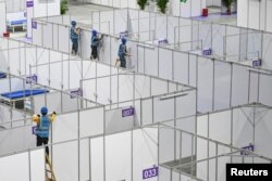 FILE - Workers set up equipment inside Pazhou International Convention Exhibition Center to convert it into a makeshift hospital for the coronavirus disease (COVID-19), in Guangzhou, Guangdong province, China April 10, 2022. (cnsphoto via Reuters)