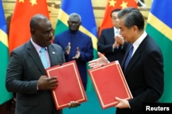 Penasihat Negara dan Menteri Luar Negeri China Wang Yi dan Menteri Luar Negeri Kepulauan Solomon Jeremiah Manele menghadiri upacara penandatanganan di Aula Besar Rakyat di Beijing, China, 9 Oktober 2019. (Foto: Reuters)