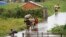 FILE - Residents wade through flood water around their homes after heavy rain in Antananarivo, Madagascar, Jan. 19, 2022. 