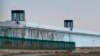 FILE - A person stands in a tower on the perimeter of the No. 3 Detention Center in Dabancheng, in China's Xinjiang Uyghur Autonomous Region, April 23, 2021. Rights groups have accused China of committing massive crimes against Uyghurs and other Turkic Muslim populations.