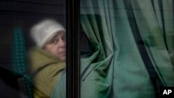 A person looks out a bus window as civilians are evacuated from Irpin, on the outskirts of Kyiv, Ukraine, March 9, 2022