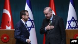 Presiden Israel Isaac Herzog, kiri, berdiri di samping timpalannya dari Turki Tayyip Erdogan setelah konferensi pers di Ankara, pada 9 Maret 2022. (Foto: AFP)