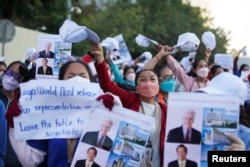 រូបឯកសារ៖ បុគ្គលិកក្រុមហ៊ុនណាហ្គាវើលដ៍ម្នាក់កាន់បដាធ្វើបាតុកម្មតវ៉ានៅមុខរដ្ឋសភាជាតិ ក្នុងរាជធានីភ្នំពេញ កាលពីថ្ងៃទី ៤ ខែមករា ឆ្នាំ ២០២២។