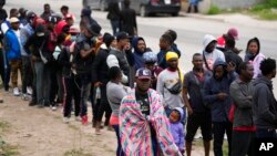 Haitians seeking asylum in the U.S. gather along the U.S.-Mexico border as they wait to register with a religious organization, in Reynosa, Mexico, Dec. 21, 2022.