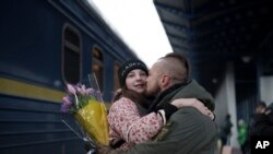 42岁乌克兰军人赫姆科在基辅中央火车站高兴地接到了久别的女儿和妻子（2022年12月31日）