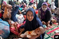 Pengungsi etnis Rohingya duduk di tempat penampungan sementara di Aceh Utara, Indonesia, Selasa, 15 November 2022. (AP Photo/Zik Maulana)