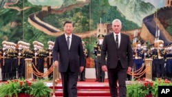 Presiden China Xi Jinping (kiri) dan Presiden Kuba Miguel Diaz-Canel Bermudez berjalan beriringan dalam acara penyambutan di Beijing, pada 25 November 2022. (Foto: Ding Lin/Xinhua via AP)