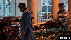 上海医护人员在运送一名病人进入医院的发热门诊。（2022年12月19日）