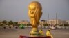 Pekerja duduk di samping replika Piala Dunia di luar Stadion Lusail jelang Piala Dunia, di Lusail, Qatar, 10 November 2022 REUTERS/Marko Djurica