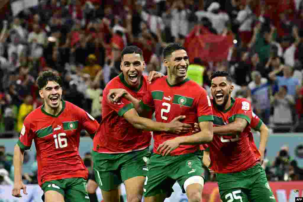 Défenseur ya Maroc #02 Achraf Hakimi (G2) azali kosepela na bainga ba ekipi na ye nsima na elonga na penalty likolo lya Espagne na 8e ya finale ya Mondial Qatar 2022, na stade Al-Rayyan, Doha, 6 décembre 2022. (Photo by JAVIER SORIANO / AFP)