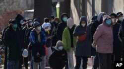 北京居民在一所医院的发热门诊前大排长龙。（美联社2022年12月11日照片）