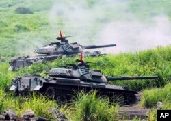 Tank-tank Pasukan Bela Diri Darat Jepang menembakkan peluru selama latihan militer di kaki Gunung Fuji di Jepang tengah pada Kamis, 21 Agustus 2008. (Foto: AP/Katsumi Kasahara)
