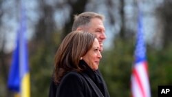 U.S. Vice President Kamala Harris, foreground, and Romanian President Klaus Iohannis attend a welcome ceremony in Bucharest, Romania, March 11, 2022. 