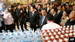 FILE - Cambodian Prime Minister Hun Sen, center right, tours an AEON mall accompanied by Japanese Foreign Minister Fumio Kishida, center left, in Phnom Penh, Cambodia, June 30, 2014. Kishida, now Japan's prime minister, will meet with Sen this weekend in 